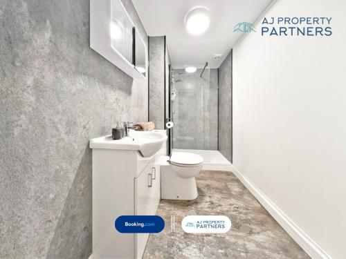a bathroom with a white sink and a toilet at Premium Offer l Last-Minute Escape l AJ Properties l High Street Cheltenham l Parking l Ideal for Short or Long Stays - Town Centre Apartment, 4 Beds, 1 Bathroom in Cheltenham