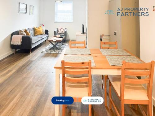 a living room with a dining table and a couch at Premium Offer l Last-Minute Escape l AJ Properties l High Street Cheltenham l Parking l Ideal for Short or Long Stays - Town Centre Apartment, 4 Beds, 1 Bathroom in Cheltenham