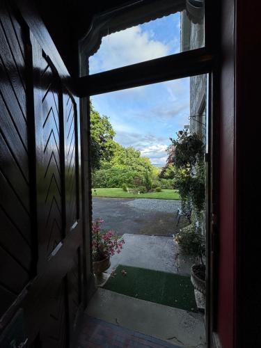 an open door with a view of a driveway at Wellwood Manor in Pitlochry