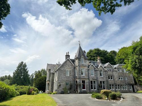 an old stone mansion with a sky at Wellwood Manor in Pitlochry