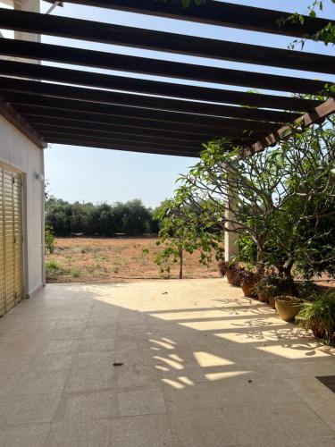 a patio with awning and trees in a field at Erini Villa in Protaras