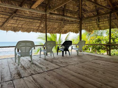 a group of chairs sitting under a pavilion on the beach at HOSPEDAJE DOÑA NEL in El Valle