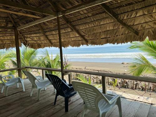 a row of chairs on a deck with a beach at HOSPEDAJE DOÑA NEL in El Valle