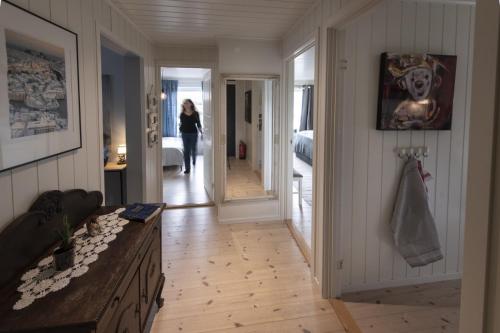 a woman walking down a hallway in a house at Koselig leilighet i sentrum in Ålesund