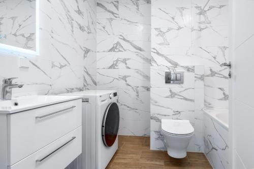 a white bathroom with a toilet and a sink at Two room Apartment - self check-in in Vilnius