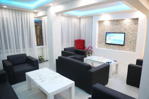 a waiting room with chairs and a tv on a wall at Konyaaltı HOTEL in Antalya