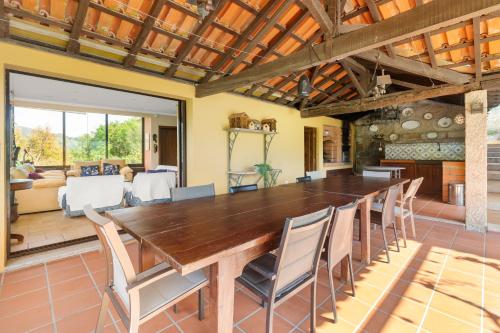 a dining room with a large wooden table and chairs at Villa no Douro - Quinta de Pias in Cinfães