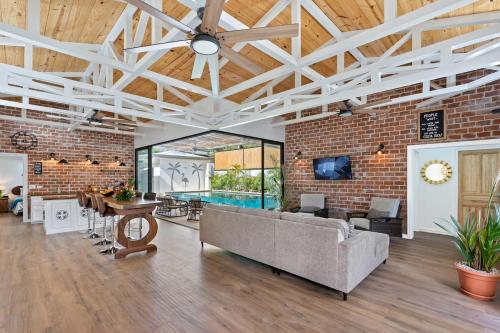 a living room with a couch and a brick wall at Swim-Through Glass Pool Villa, 5min Beach in Playa Flamingo