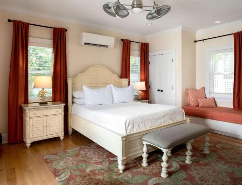 a bedroom with a white bed and red curtains at The Gardens Hotel in Key West