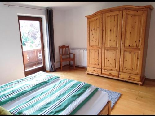 a bedroom with a bed and a wooden cabinet at Ferienwohnung Gabriel in Bad Kohlgrub