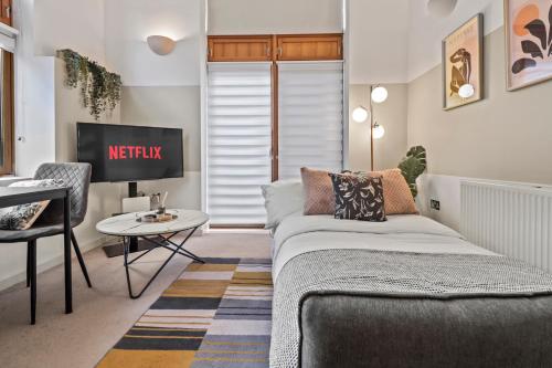 a living room with a couch and a table at Sleek Modern City Apartment in Milton Keynes