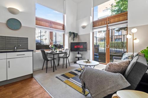 a living room with a couch and a table at Sleek Modern City Apartment in Milton Keynes