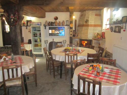a dining room with two tables and a fireplace at Guest House Popov in Marchevo