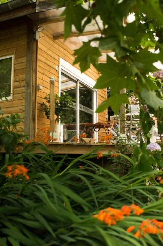 a house with a porch with a window and flowers at MAROSENIA TTIKI - Cabanes et Spa in Ascain