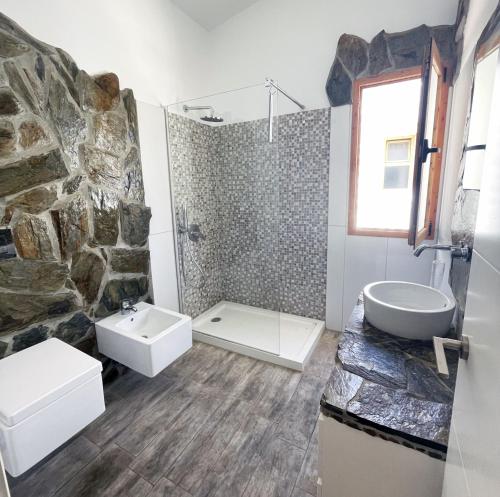 een badkamer met een stenen douche en een wastafel bij Duplex Holidays Beach in San Bartolomé