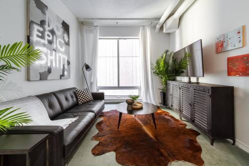 a living room with a leather couch and a table at Chic & Cozy Loft near Rogers Place, LRT, Jasper Ave in Edmonton