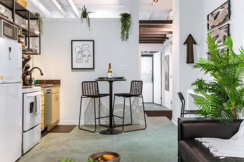 a kitchen and living room with a table and chairs at Chic & Cozy Loft near Rogers Place, LRT, Jasper Ave in Edmonton