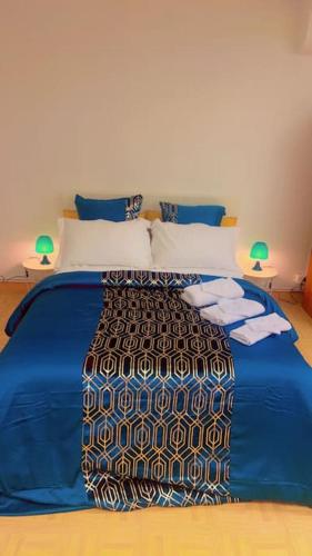 - un grand lit bleu dans une chambre avec deux lampes dans l'établissement Nid Douillet Chalon Centre Studio Spacieux, à Chalon-sur-Saône