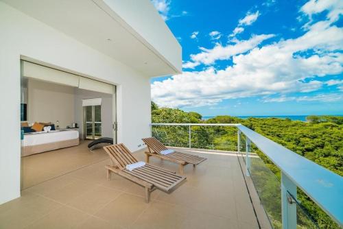a bedroom with a balcony with a view of the ocean at Ocotal Luxury Villa with Private Pool in Ocotal