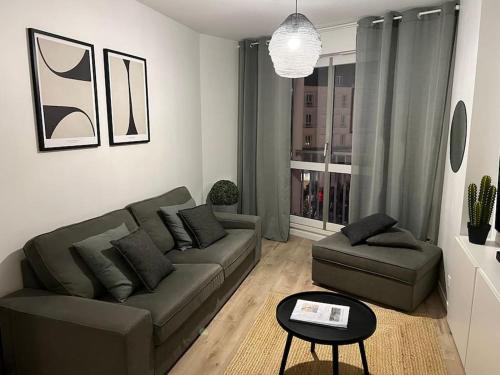 un salon avec un canapé et une table dans l'établissement Appart Cosy emplacement N1 Théâtre, à Cherbourg en Cotentin