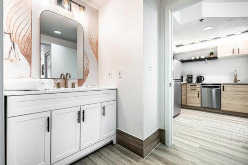 a white bathroom with a sink and a mirror at Apartment - near Epic Universe and Universal, free parking in Orlando