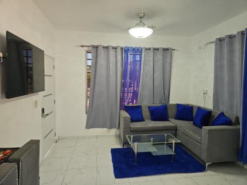a living room with a couch and blue pillows at Victor Malecon 1B in San Pedro de Macorís