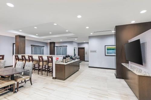 a waiting room with a bar with chairs and a television at TownePlace Suites by Marriott Austin Northwest The Domain Area in Austin