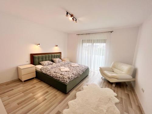 a bedroom with a bed and a chair at Casa dulce casa in Dumbrăviţa