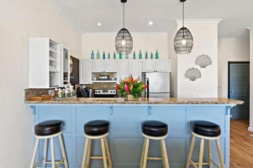 a kitchen with a blue island with stools at Picturesque Beachfront Condo w - Pool in Playa Flamingo
