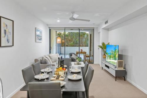 a living room with a couch and a table and chairs at Modern 2B2B Suit only 10mins to Airport n Southbank in Brisbane