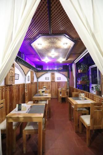 a dining room with wooden tables and purple lighting at Dar Belmamoun in Fez