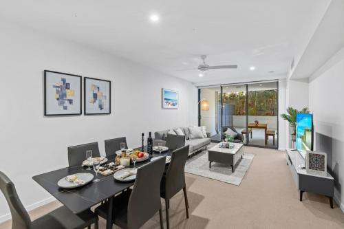 a dining room and living room with a table and chairs at Modern 2B2B Suit only 10mins to Airport n Southbank in Brisbane