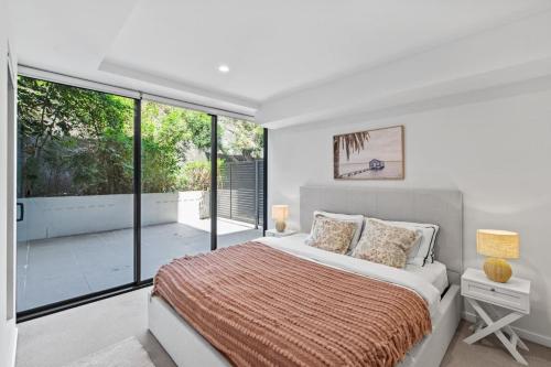 a bedroom with a large bed and a balcony at Modern 2B2B Suit only 10mins to Airport n Southbank in Brisbane