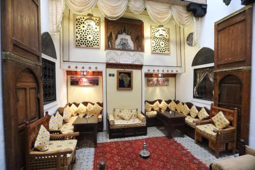 a living room with couches and a rug at Dar Belmamoun in Fez