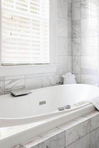 a white bath tub in a bathroom with a window at The Gardens Hotel in Key West