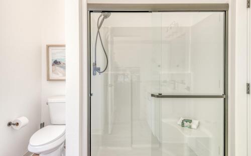 a bathroom with a glass shower with a toilet at Harbor Lights #1 - New Construction Townhome in Depoe Bay