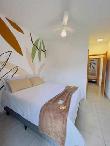 a bedroom with a bed and a ceiling fan at Apê 212 - Piscina, Churrasqueira, 2 Quartos a 600m da Orla Central in Ubatuba