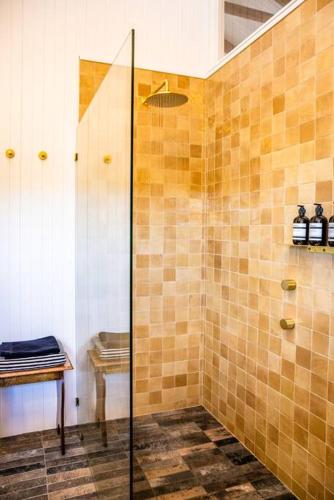 a shower with a glass door in a bathroom at Three Gums Mudbrick in Crescent Head