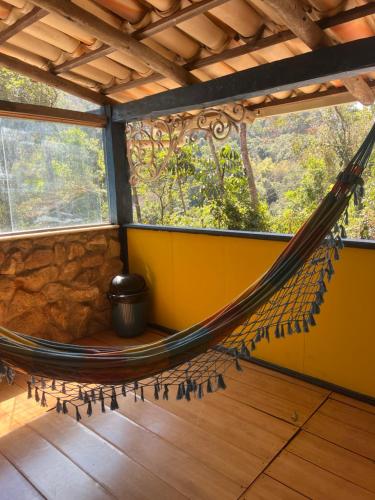 a hammock in a room with a window at Pousada Lua Bonita in Nova Lima