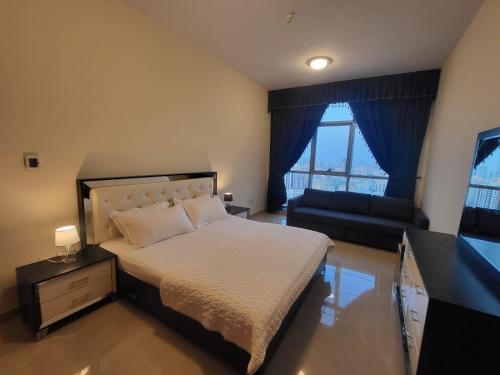a bedroom with a large bed and a couch at Sunset Sea view Furnish Apartment in Ajman 