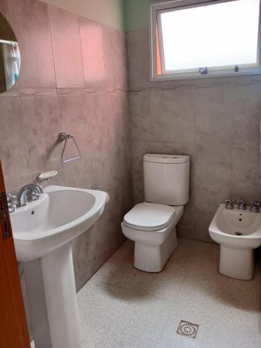 a bathroom with a sink and a toilet and a window at Sauces Las Chacras in Juana Koslay 