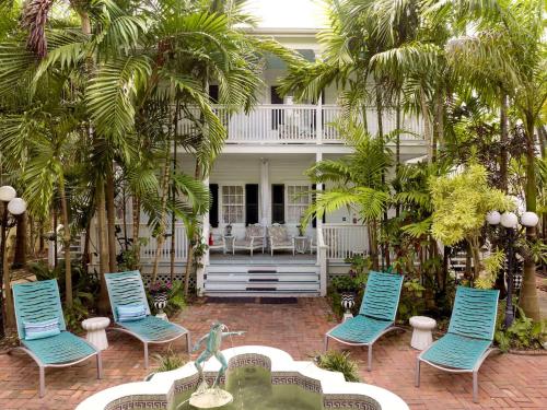 a group of blue chairs in front of a house at The Gardens Hotel in Key West