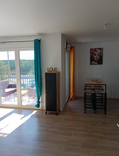 d'un salon avec une table et une porte coulissante en verre. dans l'établissement Ma vie Mes règles Mon havre de paix à 45 mn de Paris, à Dreux
