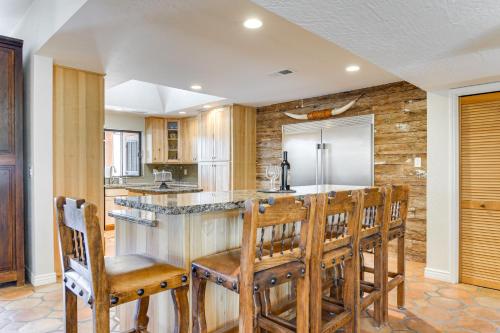 a kitchen with a bar with wooden chairs at Full Circle Ranch with Pool and Views in Cave Creek in Cave Creek