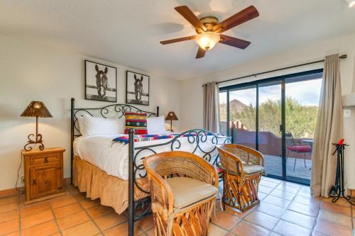 a bedroom with a bed with a ceiling fan and chairs at Full Circle Ranch with Pool and Views in Cave Creek in Cave Creek