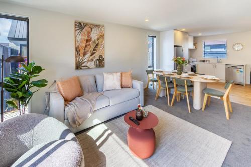 a living room with a couch and a table at The Kind Kiwi A brand new home in Riccarton in Christchurch