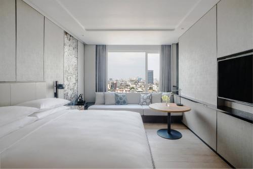 a hotel room with two beds and a tv at Bangkok Marriott Hotel The Surawongse in Bangkok