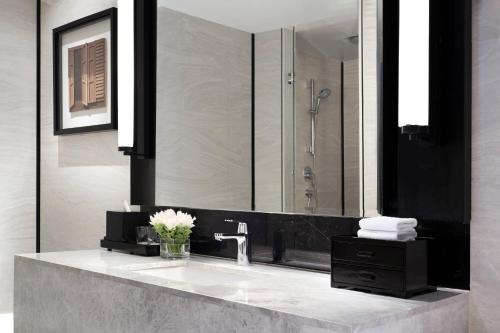 a bathroom with a sink and a large mirror at Bangkok Marriott Hotel The Surawongse in Bangkok