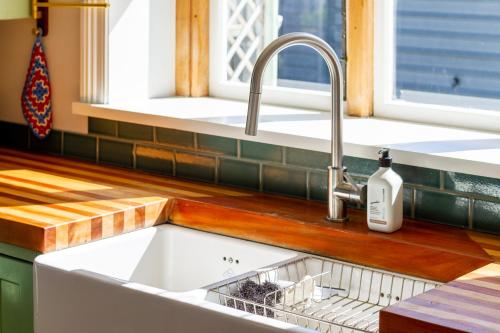 a kitchen sink with a dish rack in it at Charming 3-Bedroom Retreat in Christchurch
