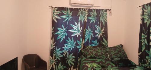 a room with a chair and a curtain with plants at Beautiful 1-Bedroom in St Thomas Jamaica in Belfast
